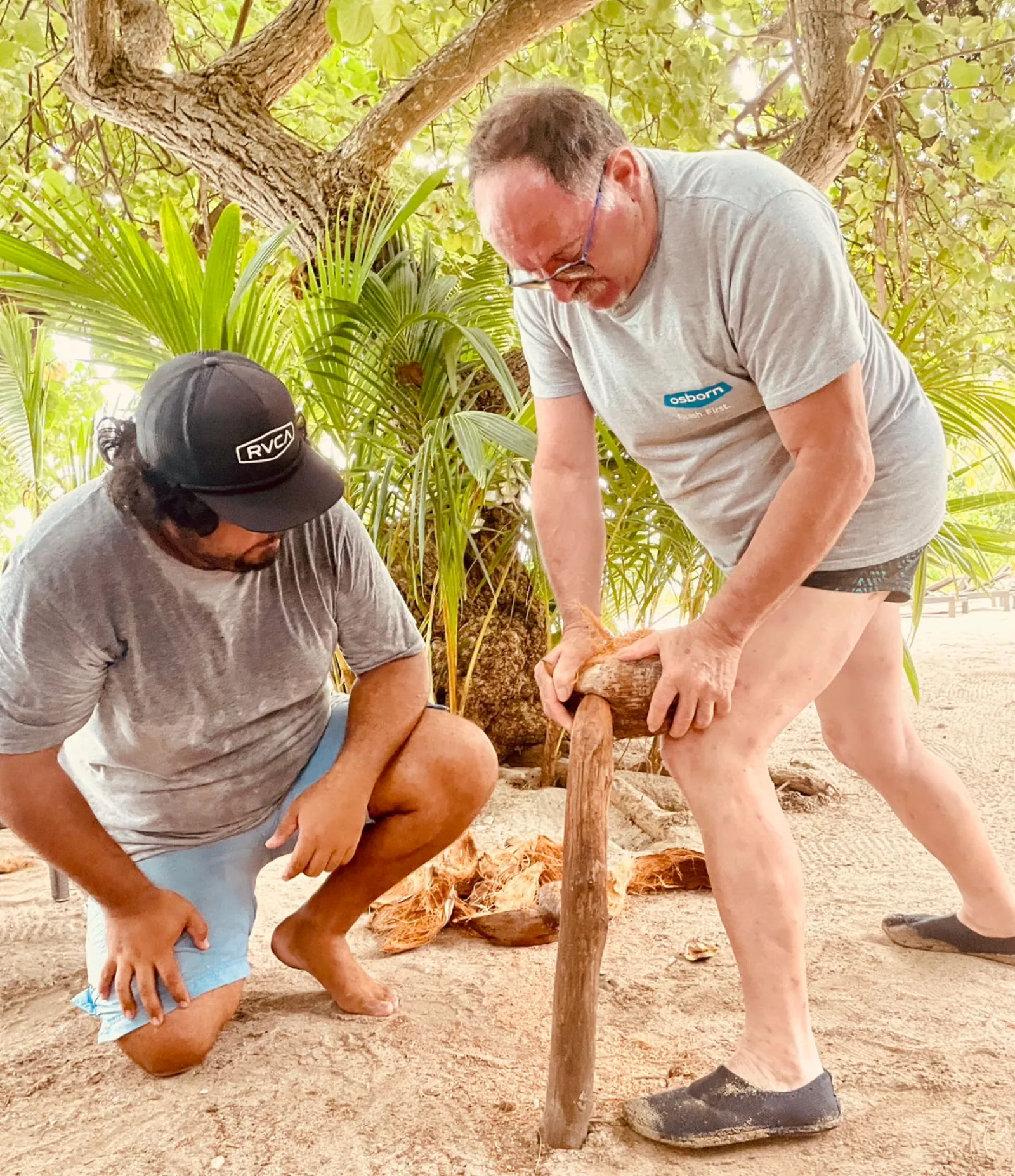 Guides opening coconuts on the motu