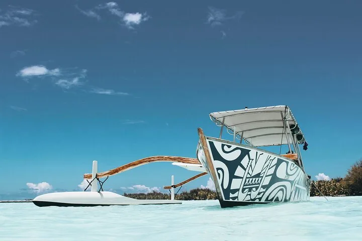 Lagoon Service boat with a painted canopy anchored in shallow turquoise water