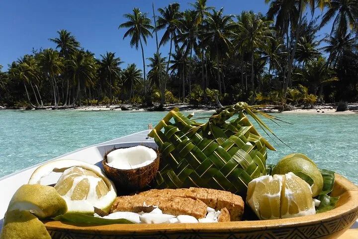 Coconuts and fruit laid out on palm leaves on a motu