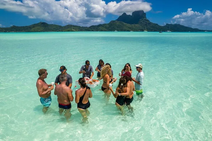 Guests standing waist-deep in a shallow bay