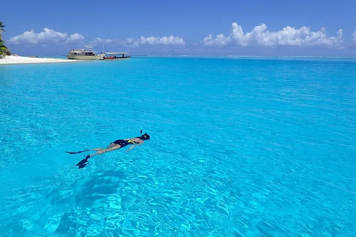 Snorkeller floating over pale turquoise shallows