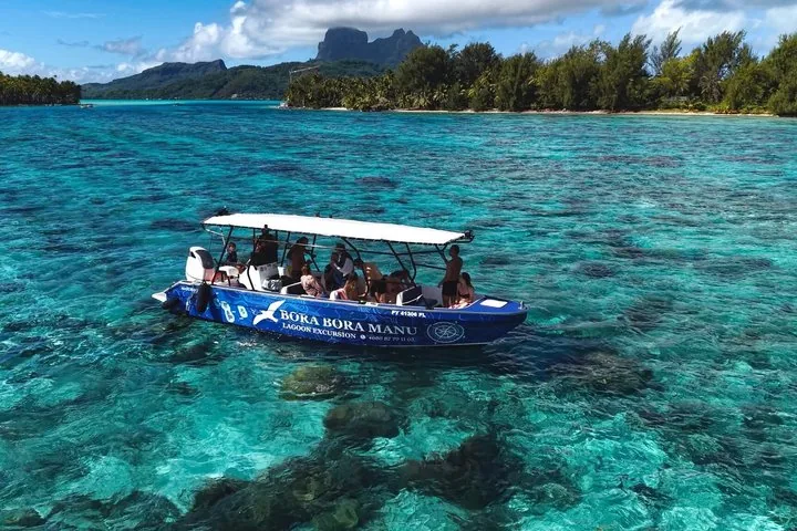 Covered boat over coral heads near the shore