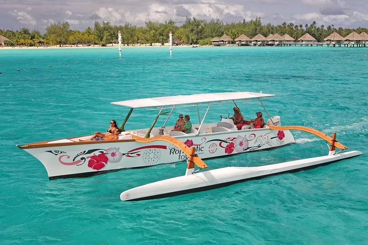 Polynesian outrigger canoe in shallow water off a motu